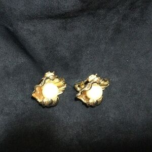 Pearl earrings in gold metal clam shell.